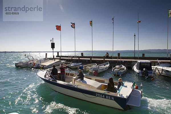 Ein Motorboot mit Touristen verlässt den Hafen  Sirmione  Gardasee  Lago di Garda  Lombardei  Italien  Europa