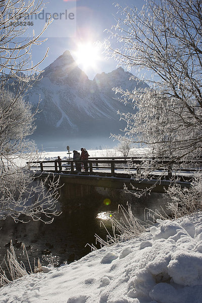 Wanderer stehen auf einer verschneiten Brücke  hinten die Sonnenspitze  Tirol  Österreich  Europa