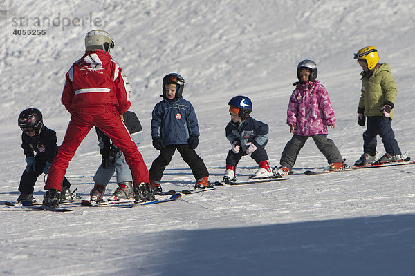 Kinder werden von einer Skilehrerin in einem Anfängerkurs in einer Skischule unterrichtet und fahren einen Berghang herunter  Ehrwald  Tirol  Österreich  Europa