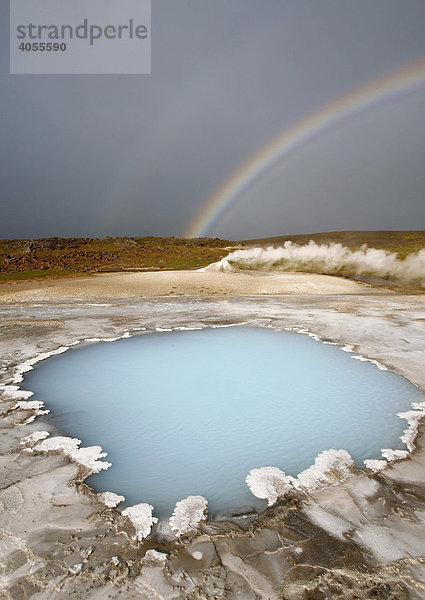 Der Bláhver  blaue Quelle  das schönste Blauwasserbecken in Hveravellir im Hochland  dahinter der Öskjuholt  ein dampfender Sinterkegel  der aussieht wie ein Mini-Vulkan  darüber ein Regenbogen  Hveravellir  Island  Europa