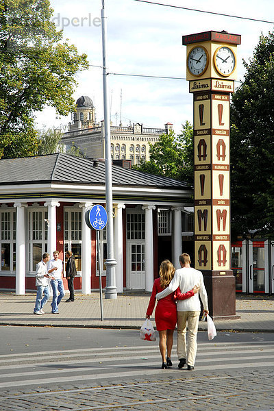 Aspazijas bulvaris Boulevard  ein Pärchen überquert die Straße zur Laima-Uhr von 1924  Reklame für die Schokoladenmarke Laima  Riga  Lettland  Latvija  Baltikum  Nordosteuropa