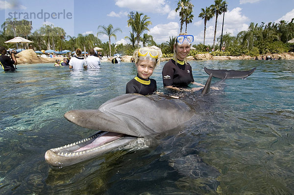 Mutter und Kind spielen mit Delfin (Tursiops truncatus)  Discovery Cove  Orlando  Florida  USA  Nord America