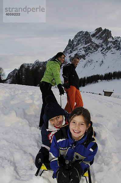 Kinder werden von den Eltern im Schlitten gezogen  Rotwand  Hochpustertal  Südtirol  Dolomiten  Italien  Europa