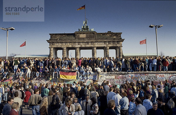 Fall der Berliner Mauer: Menschen aus Ost- und West-Berlin sind auf die Mauer am Brandenburger Tor geklettert  Berlin  Deutschland  Europa