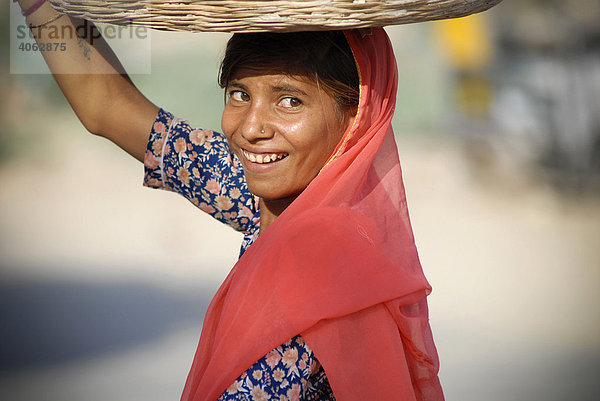 Junge Frau trägt Korb auf dem Kopf  Pokaran  Rajasthan  Nordindien  Indien  Asien