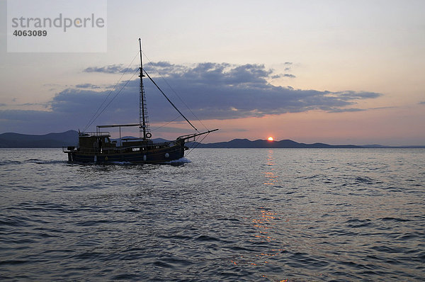 Schiff  Sonne spiegelt sich im Meer  Sonnenuntergang am Meer  Dämmerung  Zadar  Kroatien  Europa