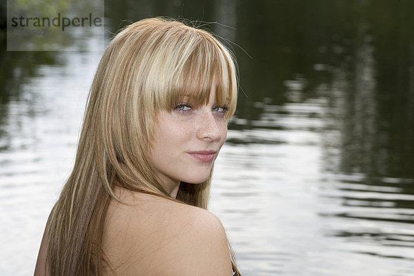 Portrait einer jungen blonden Frau am Wasser