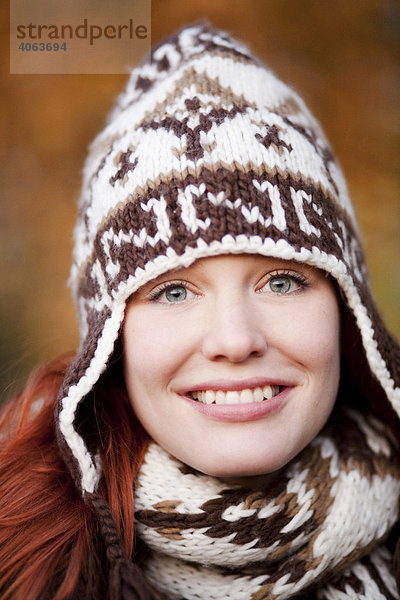 Junge rothaarige Frau mit Mütze und Schal  Portrait