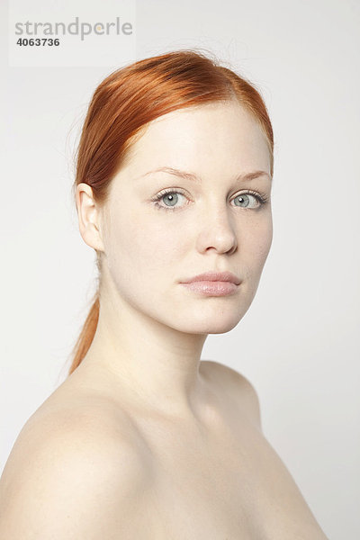 Portrait einer jungen rothaarigen Frau vor Weiß
