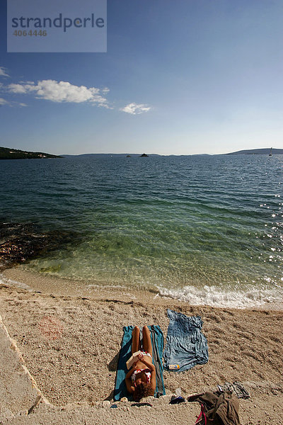 Frau beim Sonnenbaden am Strand bei Trogir  Kroatien  Europa