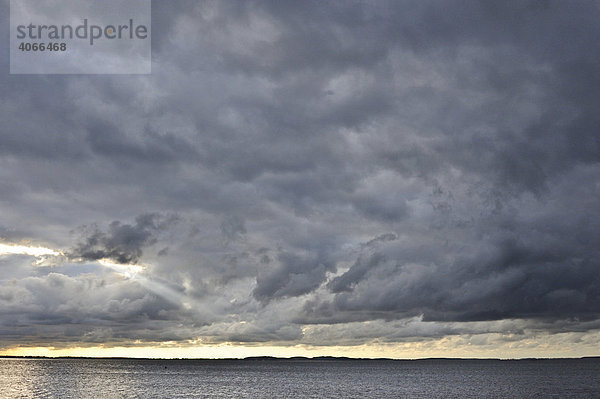 Dramatischer Abendhimmel mit goldenem Horizont und bedrohlichen Gewitterwolken  Rügen  Mecklenburg-Vorpommern  Deutschland  Europa