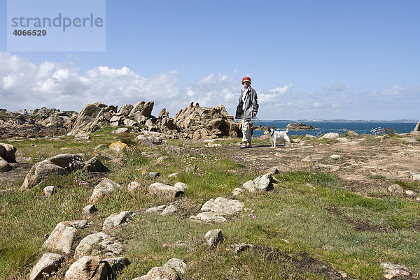 Frau geht mit Jack Russell spazieren an der Felsenküste bei Le Diben  Bretagne  Frankreich  Europa
