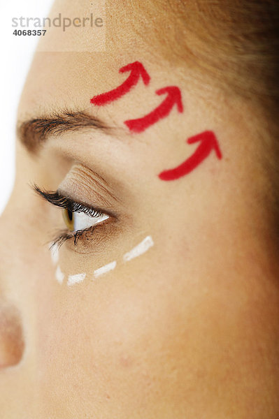 Junge Frau mit Markierungen im Gesicht für Schönheits-OP