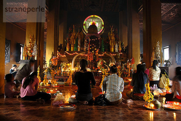 Gläubige Buddhisten opfern Gaben im Tempel Wat Simuong  Vientiane  Laos  Asien