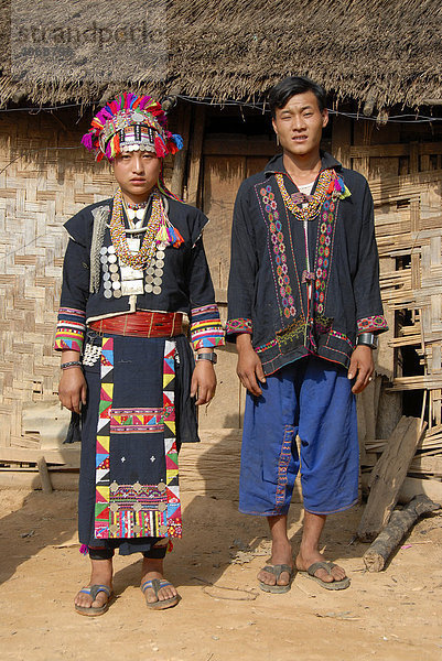 Mann und Frau der Akha Loma Ethnie  beide in bunter traditioneller Tracht gekleidet  Ban Noy  Phongsali Provinz  Laos  Südostasien