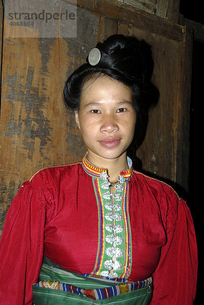 Frau der Tai Dam Ethnie mit hoch gesteckter Frisur und in bunte Tracht gekleidet  Ban Nambone Tai  Phongsali Provinz  Laos  Südostasien