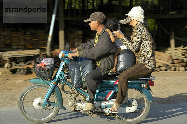 Mit Menschen und Gepäck überladenes Moped  bei Phnom Penh  Kambodscha  Südostasien