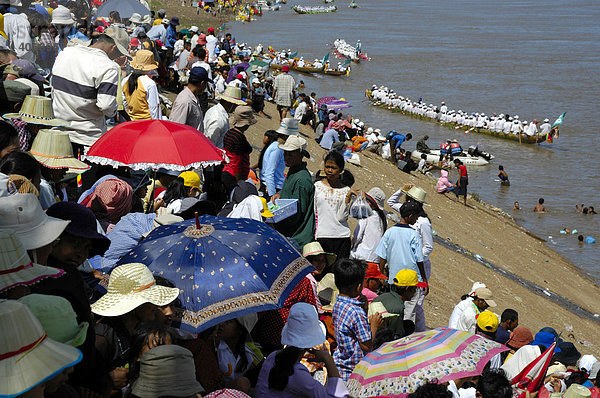 Viel Publikum unter Sonnenschirmen schaut auf große Ruderboote  Wasserfestival  Phnom Penh  Kambodscha  Südostasien