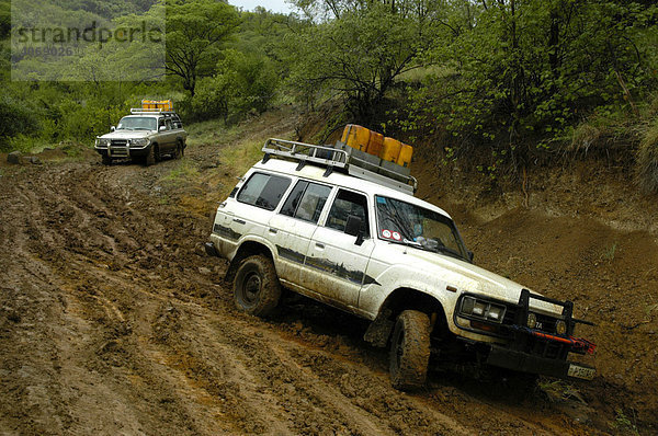 Zwei Toyota Landcruiser rutschen matschige Piste hinunter  bei Jinka  Äthiopien  Afrika
