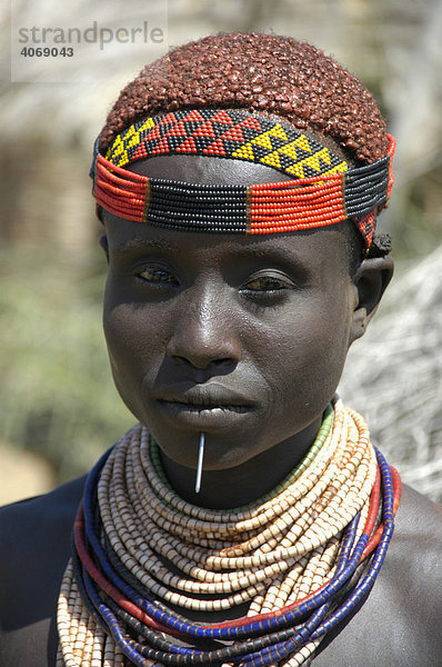 Portrait  Frau mit buntem Stirnband und rotem Lehm in den Haaren  Volk der Karo  Kolcho  Südliches Omo Tal  Äthiopien  Afrika