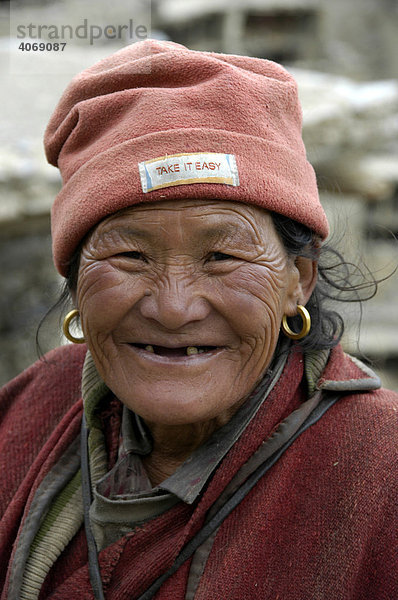 Portrait  lächelnde Tibeterin trägt Mütze mit Slogan Take it easy  Phu  Annapurna Region  Nepal  Asien
