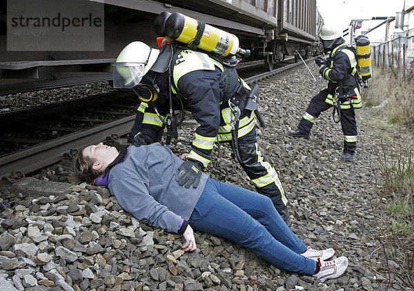 Feuerwehrleute mit Atemschutzgeräten helfen Verletztendarstellern bei einer Katastrophenschutzübung bei Poing  Bayern  Deutschland  Europa