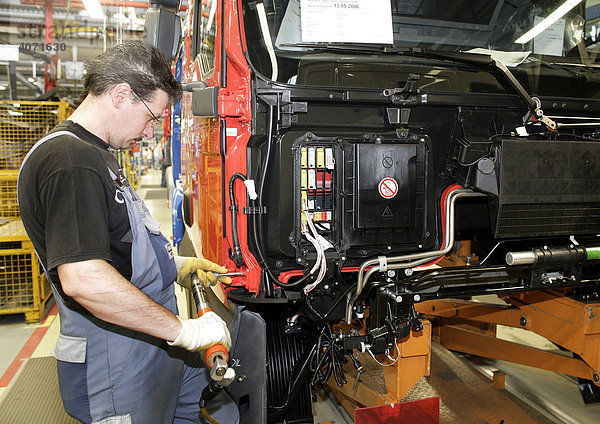 Arbeiter bei Montage einer Tür am Fahrerhaus für Lkw  Fertigung  Produktion MAN Nutzfahrzeuge AG  München  Bayern  Deutschland  Europa