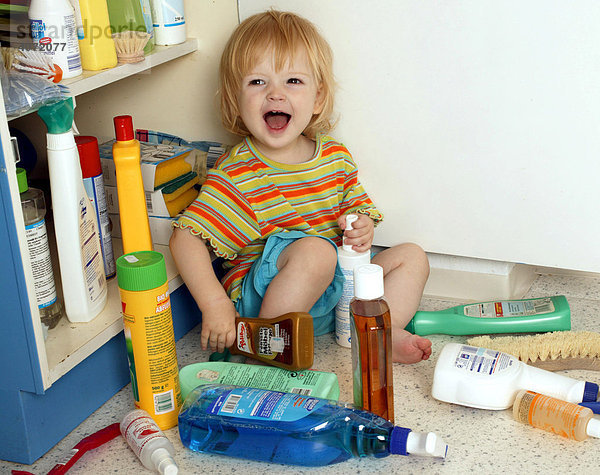 Kleinkind beim Spielen mit Reinigungsmitteln