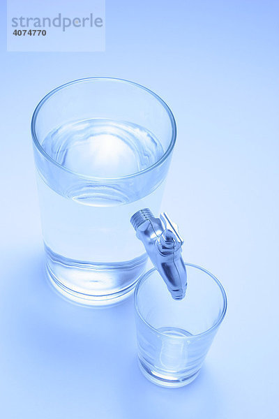 Wasserhahn der aus einem Wasserglass herauskommt