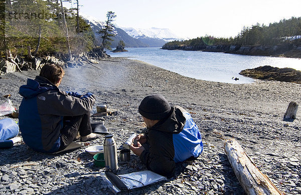 Junges Paar ruhen sich Lagerfeuer aus  Strand  Abend  Surprise Cove  Pazifische Küste  Prince William Sound  Alaska  USA