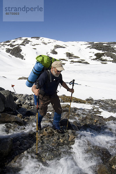 Bergsteiger mit Rucksack überquert einen Bach  Chilkoot Trail  Chilkoot Pass  British Columbia  B.C.  Kanada  Nordamerika