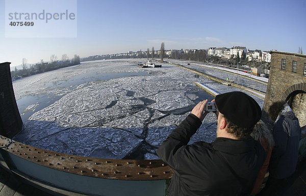Ein Spaziergänger fotografiert vom Steg der Staustufe Koblenz den Eisbrechereinsatz auf der zugefrorenen Mosel  Koblenz  Rheinland-Pfalz  Deutschland  Europa