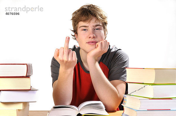 Jugendlicher sitzt genervt an seinen Hausaufgaben
