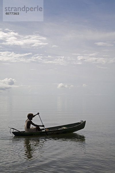 Ein Garifuna-Mann bricht in seinem Kanu zur Fischjagd mit Speer auf  Hopkins Bay in der Karibischen See  Hopkins  Belize  Zentralamerika