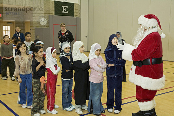 Santa Claus besucht die Salina Elementary School Grundschule  um Geschenke an die Schüler zu verteilen  die zum größten Teil aus muslimischen Immigranten-Familien stammen  Dearborn  Michigan  USA