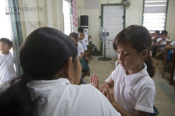 Eine Lehrerin im Einzelunterricht mit einer Schülerin der Grundschule St. Peter's Elementary School  San Pedro  Belize  Zentralamerika