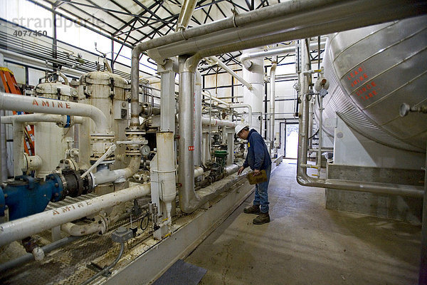 Ein Arbeiter kontrolliert die Messgeräte einer Erdgas-Aufbereitungsanlage  welche Kohlendioxid vom Gas entfernt und in die Atmosphäre entlässt  Mancelona  Nord-Michigan  USA