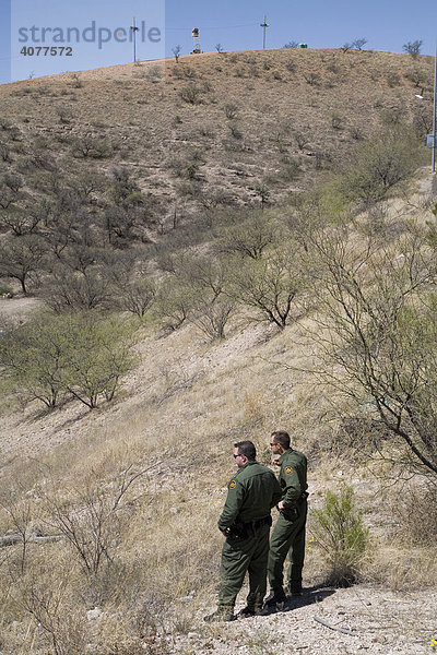 Zwei US-Grenzschutzpolizisten halten Ausschau nach mutmaßlich nicht erfassten Immigranten  die im Bereich unter ihnen gesichtet wurden  unweit der US-mexikanischen Grenze  Nogales  Arizona  USA