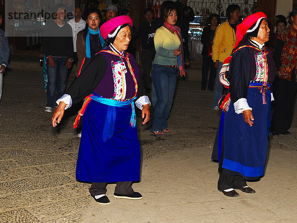 Abendlicher Tanz der Bevölkerung auf dem Stadtplatz in der Altstadt von Gyeltangteng  chinesisch Zhongdian  Tibet  China  Asien