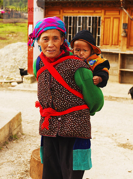 Tibeterin mit Kind auf dem Rücken bei Shenping  Deqin  tibetisch Dechen  Tibet  China  Asien