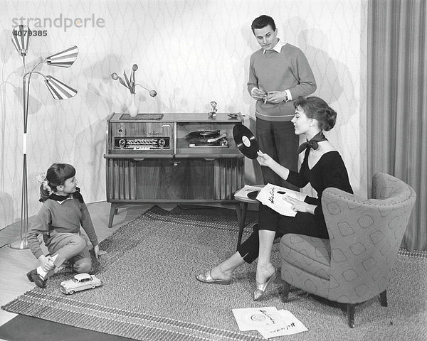 Familie im Wohnzimmer vor Stereoanlage  historische Aufnahme  ca. 1955