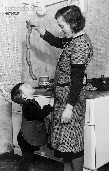 Mutter ködert Jungen mit Würsten  historische Aufnahme  ca. 1940