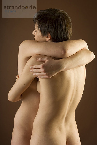 Zwei nackte junge Frauen umarmen sich