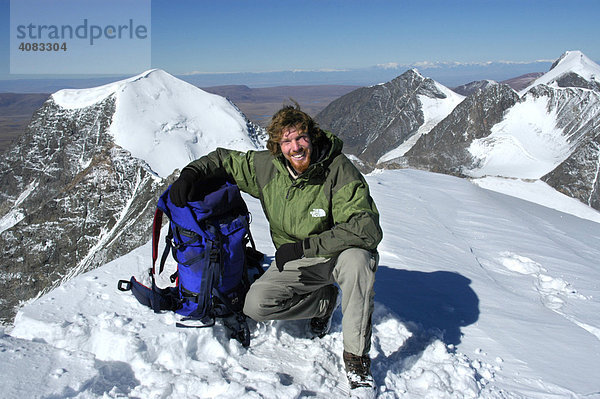 Bergsteiger mit Rucksack auf dem schneebedeckten Gipfel des Turgen Uul Kharkhiraa Mongolischer Altai bei Ulaangom Uvs Aimag Mongolei