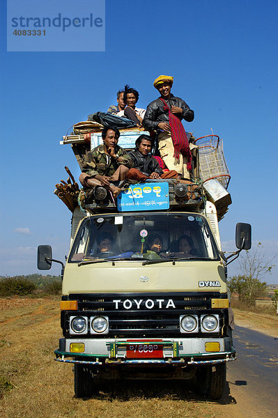 Viele Männer und Gepäck stapeln sich auf dem Dach eines Toyota Kleinlasters bei Pindaya Shan State Burma