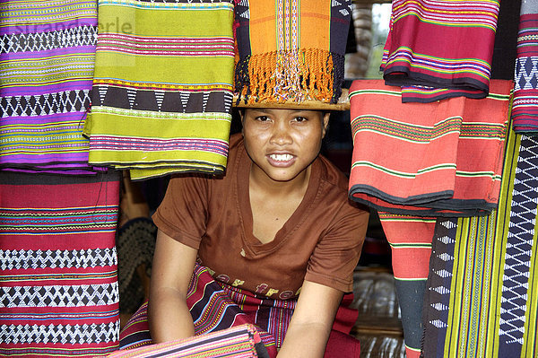 Frau vom Volk der Katou schaut durch bunte handgewebte Stoffe Bolaven Bolovens Plateau bei Pakse Laos
