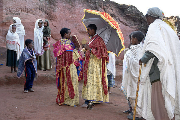 Äthiopisch orthodoxes Christentum Priester bei einer Lesung aus der heiligen Schrift vor Gläubigen vor der Felsenkirche Beta Marqorewos Lalibela Äthiopien