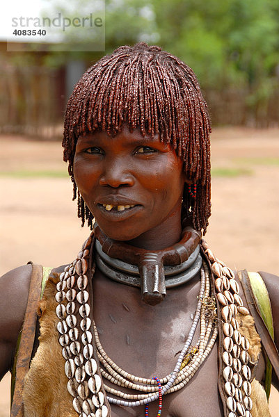 Portrait Frau vom Volk der Hamar trägt einen Umhang aus Leder und typischer Lehm Haarfrisur Ketten aus Metall und Kaurimuscheln auf dem Markt von Dimeka Äthiopien