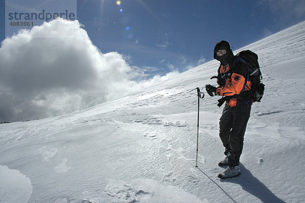 Bergsteiger in Eis und Schnee mit Wolken und Sonne Kharkhiraa Uul Mongolischer Altai bei Ulaangom Uvs Aimag Mongolei