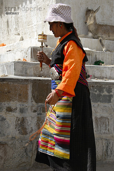 Tibetische Pilgerin in Tracht mit Gebetsmühle in der Hand Tashilhunpo Kloster Shigatse Tibet China